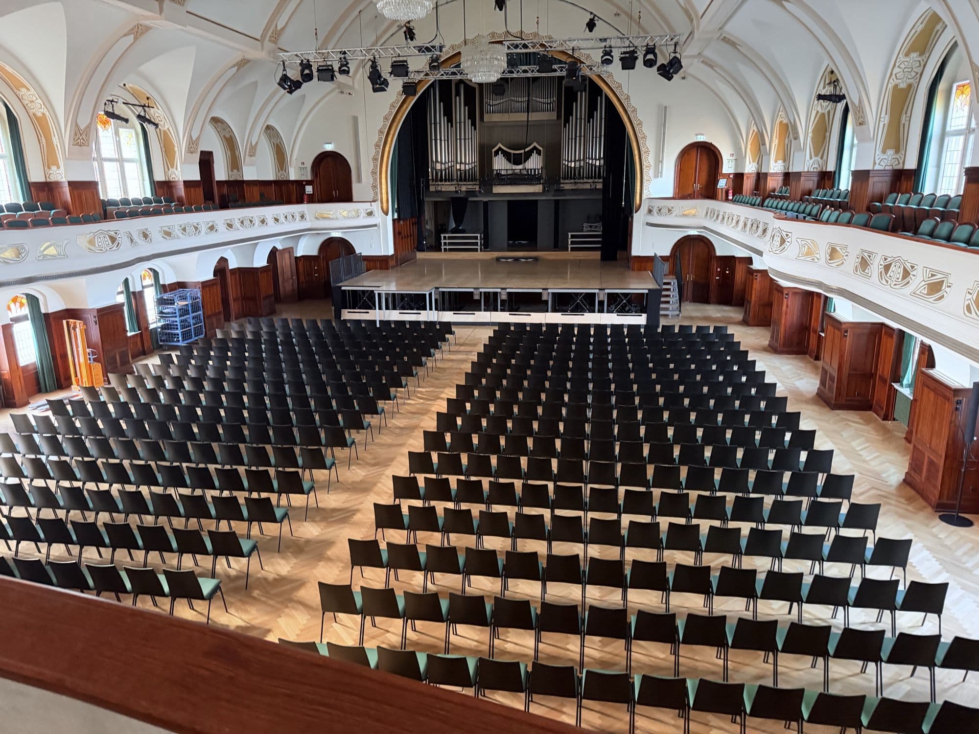 Der große Saal von der Empore aus, mit Stuhlreihen und Orgel